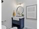 Stylish powder room with a blue vanity, round mirror, and decorative tile flooring at 10024 N 61St Pl, Paradise Valley, AZ 85253