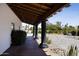 Covered patio boasts dark posts, brick flooring, and desert landscaping views at 10024 N 61St Pl, Paradise Valley, AZ 85253