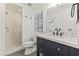 Stylish bathroom with a glass shower, modern vanity with brass accents, and black and white tile floor at 1018 W State Ave, Phoenix, AZ 85012