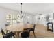 Dining room with modern chandelier, light wood floors, and plantation shutters at 1018 W State Ave, Phoenix, AZ 85012