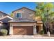 Two-story home featuring a two-car garage, neutral stucco facade, and a meticulously tiled roof at 10225 W Camelback Rd # 45, Phoenix, AZ 85037