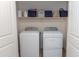 Bright laundry room includes a Whirlpool washer and dryer, and shelving for organized storage at 10225 W Camelback Rd # 45, Phoenix, AZ 85037