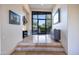 Spacious foyer with a large glass front door, tiled floors and stylish decorations and art at 10664 E Monument Dr, Scottsdale, AZ 85262