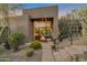Modern home featuring a stylish glass front door, desert landscaping and a stone pathway to the front entrance at 10664 E Monument Dr, Scottsdale, AZ 85262