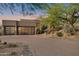 Modern home featuring three car garage and paved driveway surrounded by desert landscaping at sunset at 10664 E Monument Dr, Scottsdale, AZ 85262