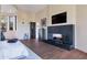 Open bedroom layout with a modern fireplace, hardwood floors, and desert views through arched windows at 10664 E Monument Dr, Scottsdale, AZ 85262