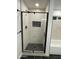 Glass enclosed shower with black hardware and niche, paired with elegant textured tile walls and herringbone floor design at 11474 N 79Th Dr, Peoria, AZ 85345