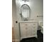 Bathroom boasts white vanity with marble top, arched mirror, and black accents, complemented by stylish black marble flooring at 11474 N 79Th Dr, Peoria, AZ 85345