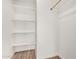 A well-organized closet features white shelves and a wooden clothes rod for efficient storage and organization at 11474 N 79Th Dr, Peoria, AZ 85345