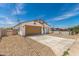 Exterior of the property featuring a two-car garage, rock landscaping, and partial fence at 11474 N 79Th Dr, Peoria, AZ 85345