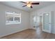 Bright living room with a ceiling fan, wood-look flooring, large window, and glass doors to another room at 1219 E Colter St # 8, Phoenix, AZ 85014