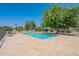 This community pool has light turquoise water, a stone patio, trees, and lounge seating for relaxation at 1219 E Colter St # 8, Phoenix, AZ 85014