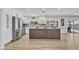 Bright kitchen features stainless steel appliances, white cabinetry, quartz countertops, and stylish vertical wood paneling on the island at 13215 N 30Th Pl, Phoenix, AZ 85032
