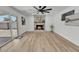 Bright living room with a stone fireplace, fan, light wood floors and sliding glass doors at 13215 N 30Th Pl, Phoenix, AZ 85032