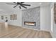 Bright living room with modern fireplace, large ceiling fan, recessed lighting, and seamless wood flooring at 13215 N 30Th Pl, Phoenix, AZ 85032