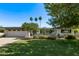 Charming single-story home with a well-manicured lawn and palm trees under a clear blue sky at 1423 E 1St St, Mesa, AZ 85203