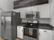 Well-equipped kitchen features stainless steel appliances, white cabinets, and gray countertops at 14728 W Redfield Rd, Surprise, AZ 85379