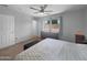 Bright main bedroom with neutral carpet, a ceiling fan, and natural light from two windows at 14728 W Redfield Rd, Surprise, AZ 85379