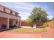 Large backyard featuring a covered patio, lush lawn, and a brick paver patio for outdoor entertaining at 15148 W Sells Dr, Goodyear, AZ 85395