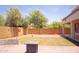 Backyard featuring a grassy area, brick paver patio, and sports-themed decor on the fence at 15148 W Sells Dr, Goodyear, AZ 85395