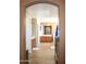 Well-lit bathroom showcasing wooden cabinetry, tile floors, and a spacious layout through an archway at 15148 W Sells Dr, Goodyear, AZ 85395