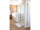 Modern bathroom featuring a glass-enclosed shower, a white bathtub, and neutral-toned walls at 15148 W Sells Dr, Goodyear, AZ 85395