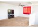 Upstairs bonus room with mounted TV, red curtains, and ceiling fan at 15148 W Sells Dr, Goodyear, AZ 85395