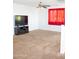 Bonus room with a flat screen television and a large window with red curtains at 15148 W Sells Dr, Goodyear, AZ 85395