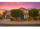 Charming home with a well-maintained lawn, mature trees, and a welcoming blue front door at 15148 W Sells Dr, Goodyear, AZ 85395