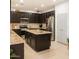 Modern kitchen featuring granite counters, stainless steel appliances, and dark wood cabinetry at 15148 W Sells Dr, Goodyear, AZ 85395