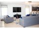 Cozy living room featuring tile floors, modern furniture, and a large flat screen TV at 15148 W Sells Dr, Goodyear, AZ 85395