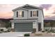 Charming two-story home with gray stucco, dark shutters, and a two-car garage at 17366 W Jessie Ln, Surprise, AZ 85387