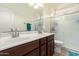 Bathroom featuring a double sink vanity with brown cabinets and an enclosed shower at 17693 W Lincoln St, Goodyear, AZ 85338
