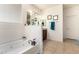 Bright bathroom featuring a soaking tub, framed mirrors, and a separated double sink vanity at 17693 W Lincoln St, Goodyear, AZ 85338