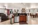Open kitchen bar featuring stainless steel dishwasher, sink, dark cabinetry, and granite countertops at 17693 W Lincoln St, Goodyear, AZ 85338