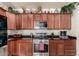 Close up view of kitchen featuring granite counters, wood cabinets, and stainless steel oven at 17693 W Lincoln St, Goodyear, AZ 85338