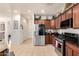 Bright kitchen features stainless steel appliances and granite countertops with dark wood cabinetry at 17693 W Lincoln St, Goodyear, AZ 85338