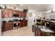 Kitchen with dark granite countertops, stainless steel appliances, and warm, wooden cabinetry at 17693 W Lincoln St, Goodyear, AZ 85338