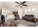 Bright living room with dark floors, a ceiling fan, and comfortable seating at 17693 W Lincoln St, Goodyear, AZ 85338