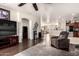 Open-concept living room with wood floors, a ceiling fan, and an archway leading to the kitchen at 17693 W Lincoln St, Goodyear, AZ 85338