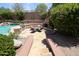 A backyard grilling and dining area with an outdoor fireplace on a beautiful stone patio at 17975 W Willow Dr, Goodyear, AZ 85338