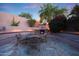 Inviting backyard area with fireplace, landscaping, and beautiful stone patio for relaxing and entertaining at 17975 W Willow Dr, Goodyear, AZ 85338