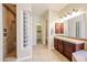 Well-lit bathroom featuring walk-in shower with glass block wall, and vanity at 17975 W Willow Dr, Goodyear, AZ 85338