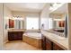 Elegant bathroom with a soaking tub, dual vanities, and tile flooring at 17975 W Willow Dr, Goodyear, AZ 85338