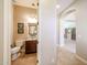 Half bathroom featuring a vanity and toilet, viewed from doorway, next to arched hallway at 17975 W Willow Dr, Goodyear, AZ 85338