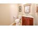 Cozy half bath boasts a vanity, toilet, and framed art in a well-lit space at 17975 W Willow Dr, Goodyear, AZ 85338