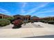 Inviting single-story home features lush desert landscaping, a brick walkway, and a two-car garage at 17975 W Willow Dr, Goodyear, AZ 85338