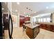 Modern kitchen featuring dark cabinets, granite counters, an island, and open design at 17975 W Willow Dr, Goodyear, AZ 85338