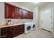 Well-equipped laundry room with washer, dryer, sink, and abundant cabinet space at 17975 W Willow Dr, Goodyear, AZ 85338