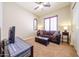 Bright living room featuring a brown couch and shutters at 17975 W Willow Dr, Goodyear, AZ 85338